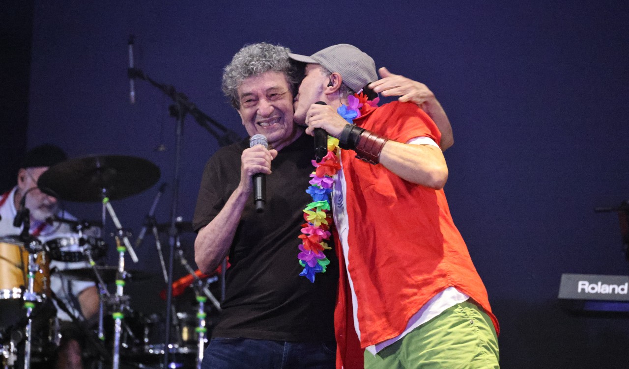 Zeca Baleiro beija Fausto Nilo no rosto durante o show